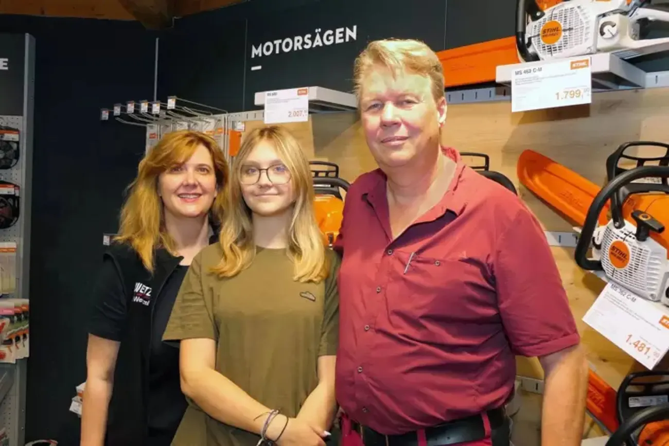 Drei Mitglieder der Familie Wetzel im Verkaufsraum vor Motorsägen