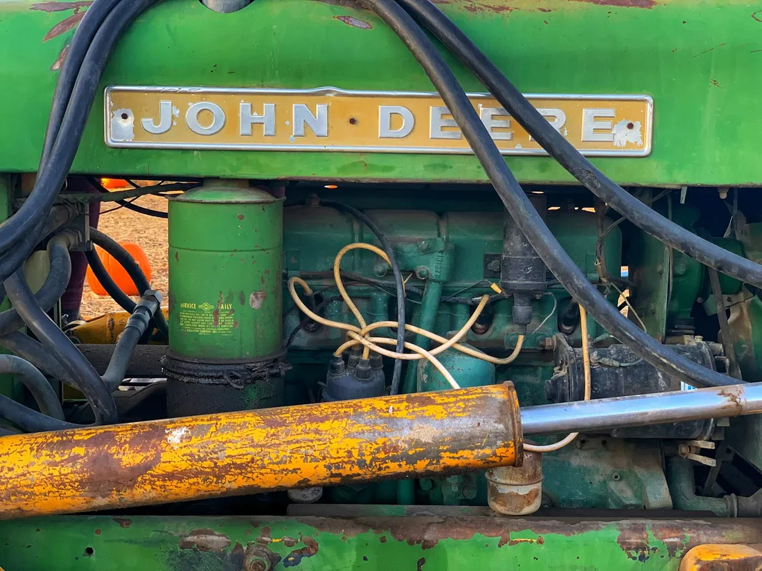 Motorraum eines John-Deere-Traktors mit Schriftzug und Schläuchen