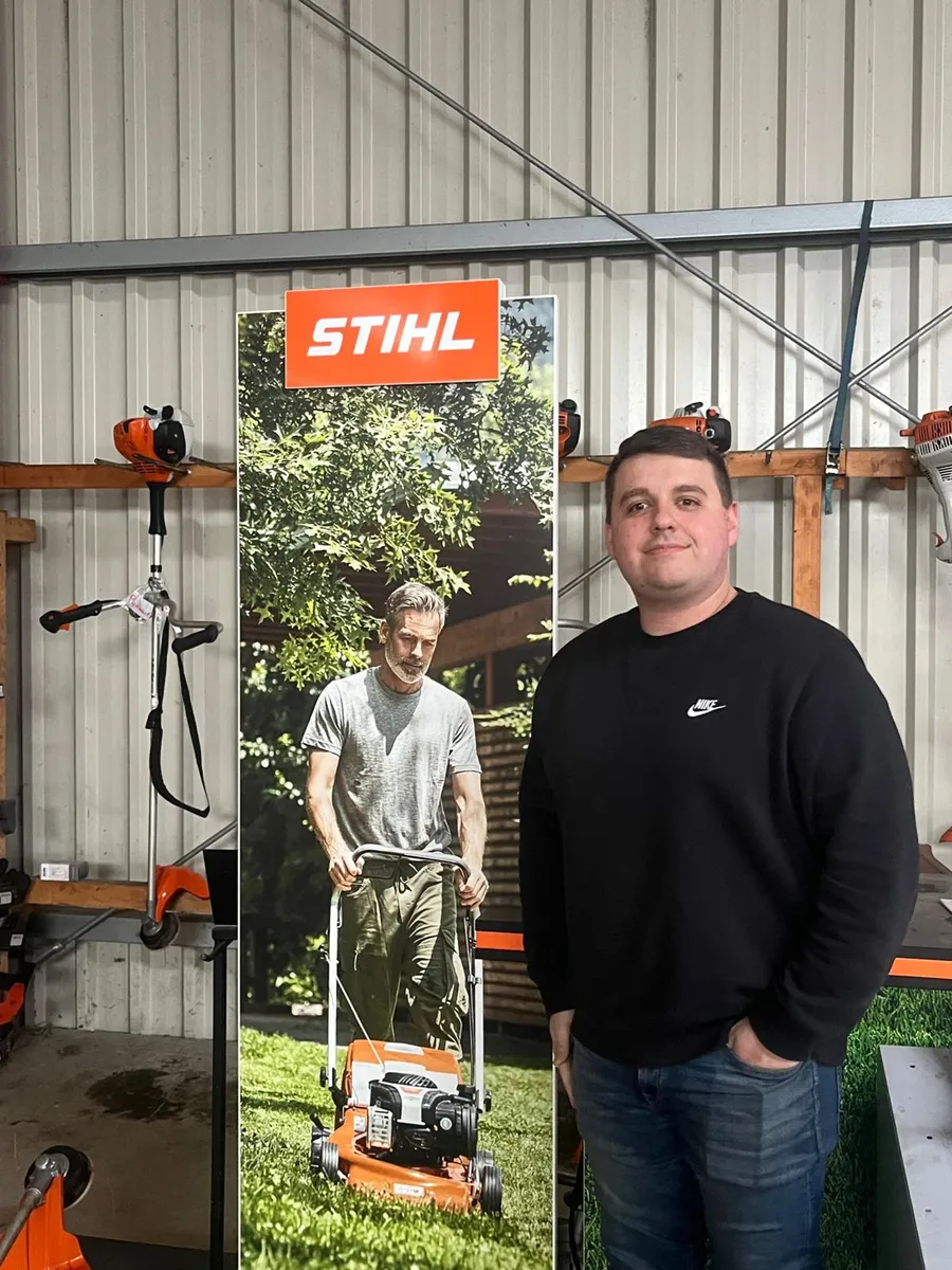 Erik Bernhardt im Verkaufsraum vor einem Stihl-Aufsteller