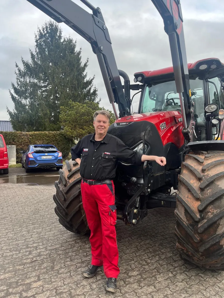Volker Wetzel vor einem roten Traktor